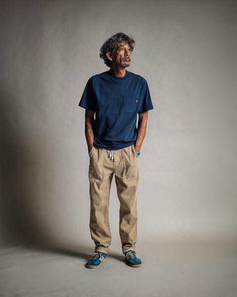A man wearing a High Tee Pocket - Navy t-shirt, khaki pants, and blue sneakers.