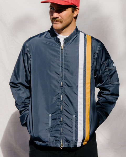 Kevin wears the Racing Jacket in Navy, White and Gold.