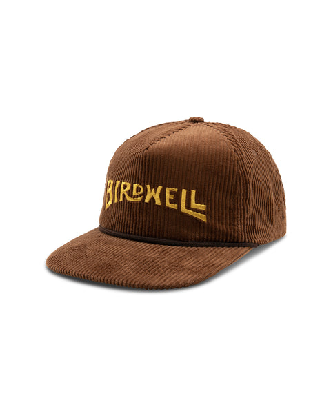 Image shows front of the Wordmark Snapback in brown. Embroidered logo on front reads 'Birdwell' in yellow.