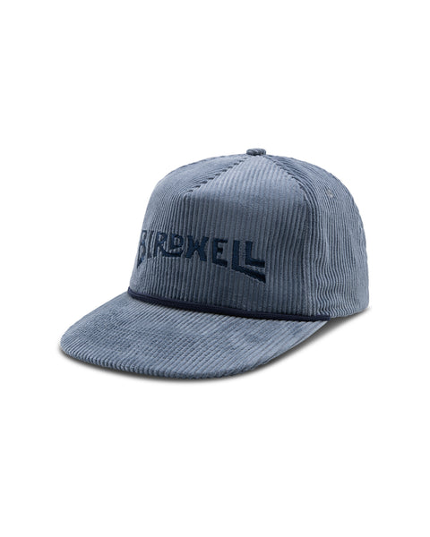 Image shows front of the Wordmark Snapback in light blue. Embroidered logo on front reads 'Birdwell' in Navy.