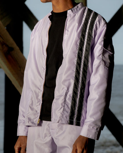 Model wears the Violet Racing Jacket and Violet Classic Board Shorts.